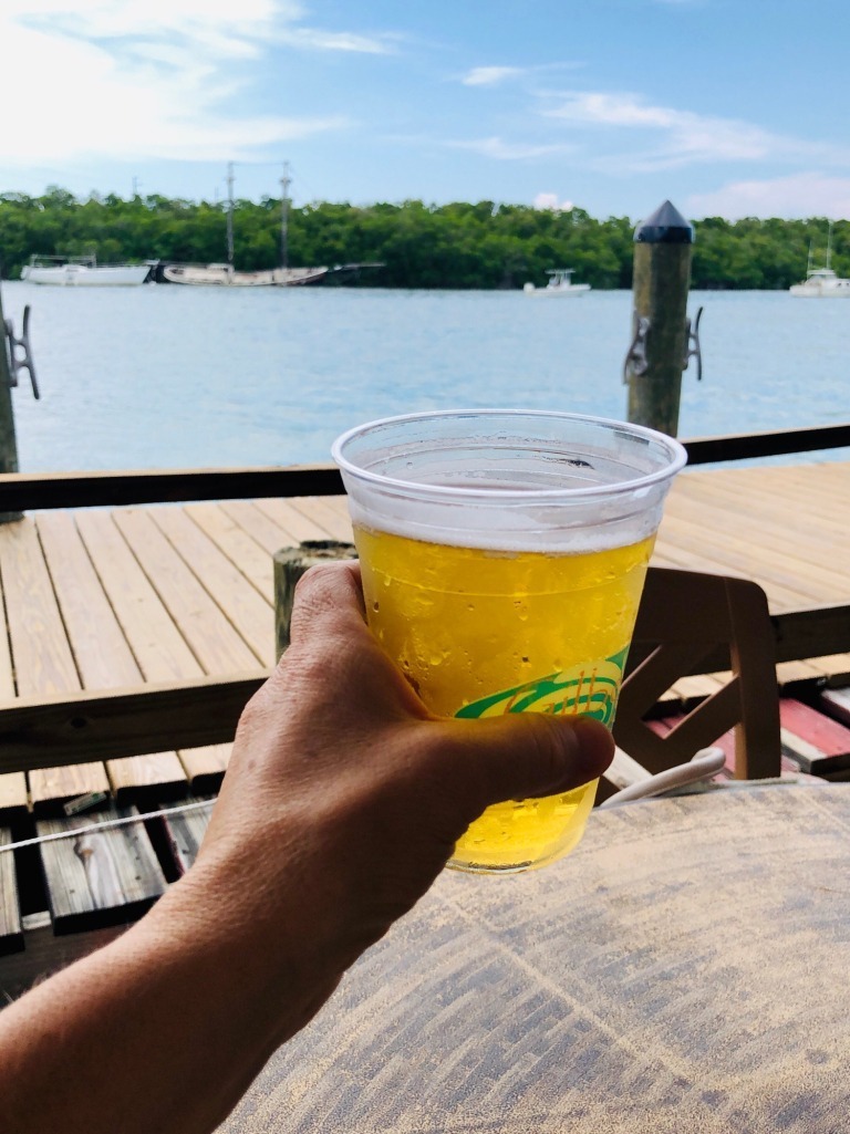 Enjoying a glass of beer while dining outdoors by the waterfront.