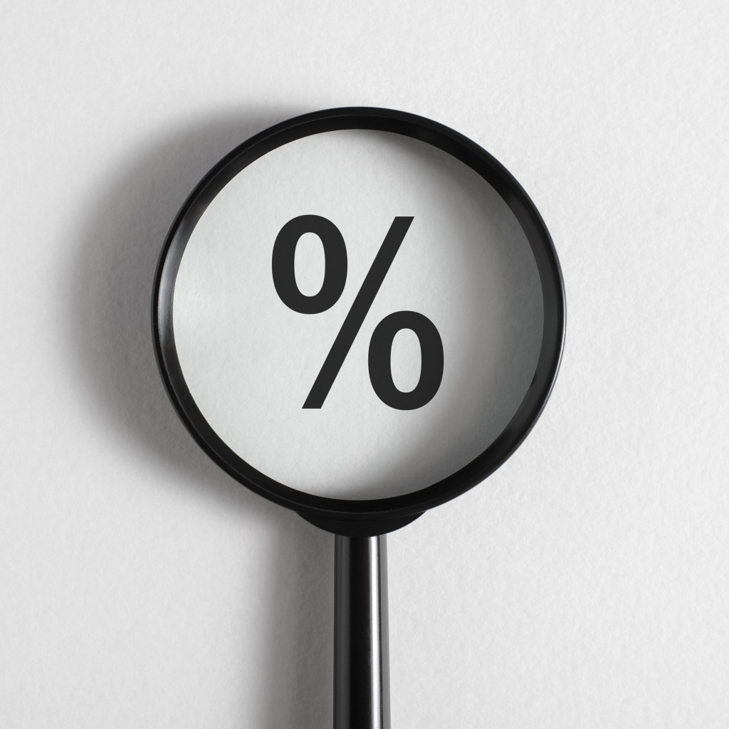 Interest rate size, financial concept. Close-up magnifying glass focused on Percentage