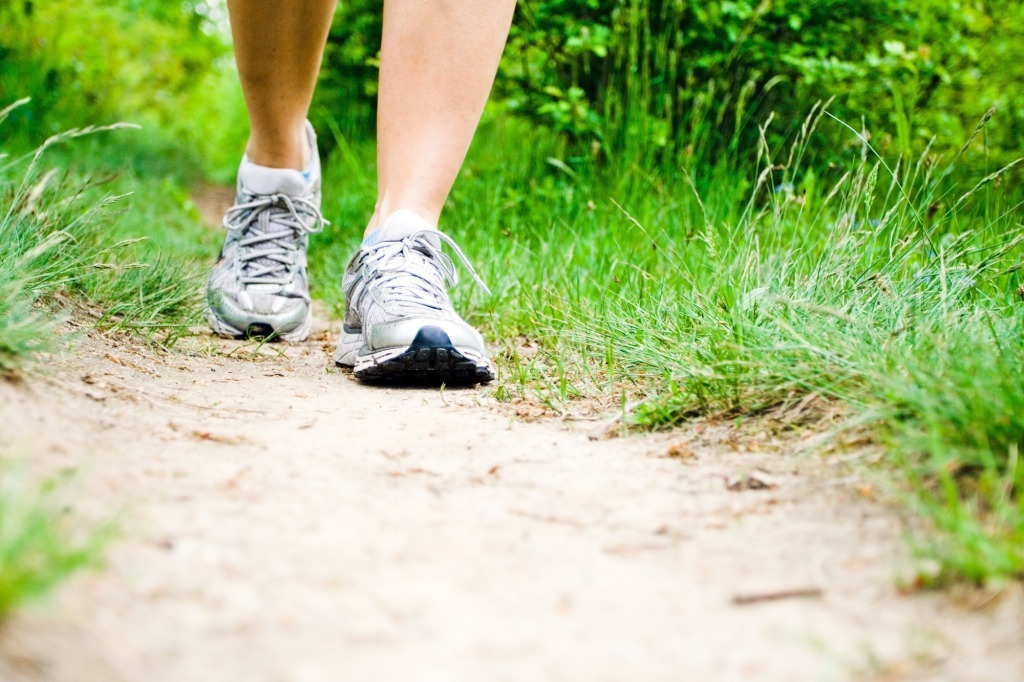 Woman walking on trail in forest
