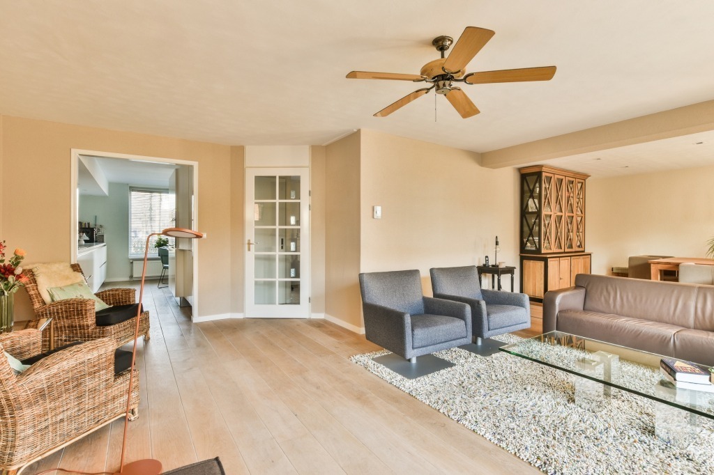a living room with a ceiling fan and couches