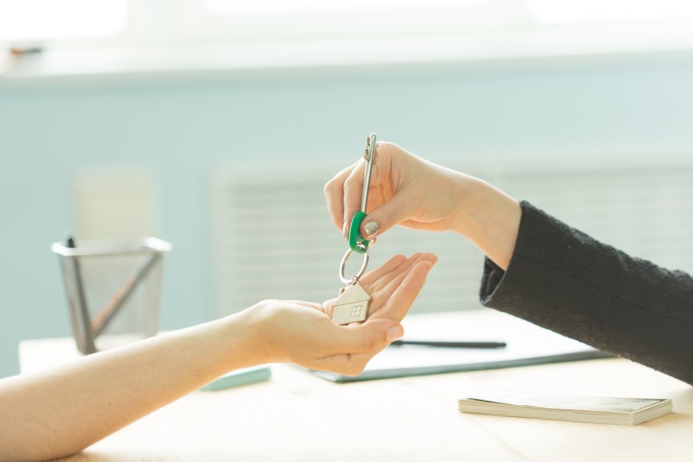 Business, realtor and real estate concept - Hand-to-hand key from new home