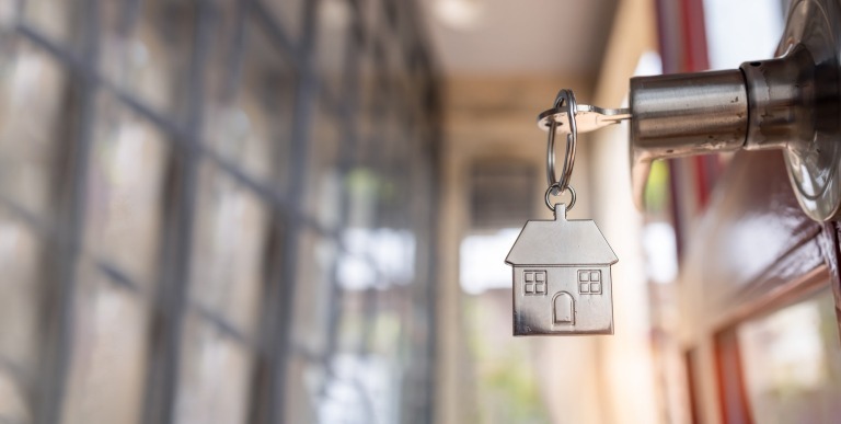 Open door to a new home. Door handle with key and home shaped Open the door and door handle with